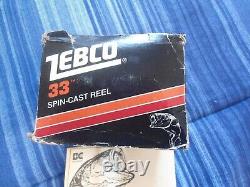 Zebco 33 vintage, neuf en stock ancien, bandes orange et or avec boîte, état neuf inutilisé.
